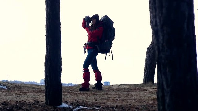 Female silhouette with backpack hiking in forest. Slow motion. HD.