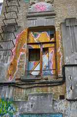 The window and wall of an abandoned house without tenants painted graffiti