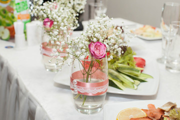 Jar with rose and baby's breath. Wedding decorations. Close-up