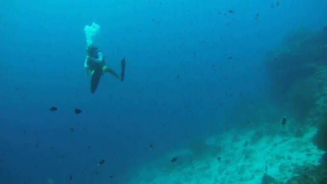 Male scuba diver swimming in blue water, Indian Ocean, Maldives
