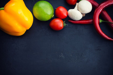 Different vegetables on a black stone background. Top view