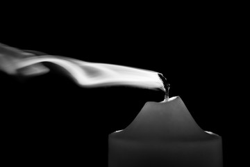 Smoke from a red candle on dark background - black and white