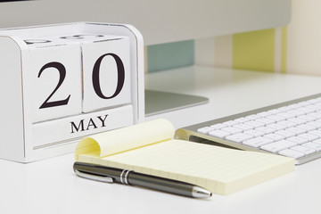 Cube shape calendar for MAY 20 and computer keyboard on table. 
