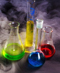 Vetreria chimica con soluzioni colorate immerse nel fumo