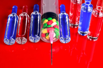Syringe for subcutaneous injections with glass ampoules and multicolored tablets on an isolated...