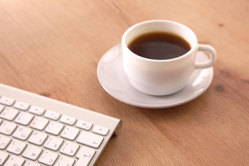 Obraz na płótnie Canvas on the desktop computer and a cup of coffee