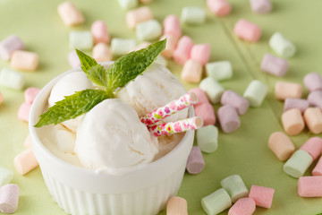lemon sorbet ice cream with mint in bowl over green background