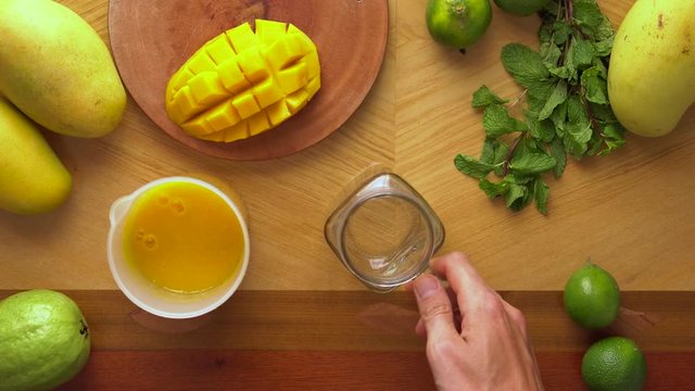Man puts a Juicy mango smoothie in a glass. Mango shake. Healthy life concept