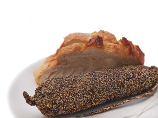 french salami sausage coated with pepper and slices of white bread 