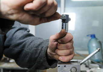 Mechanics repairing a diesel injector.