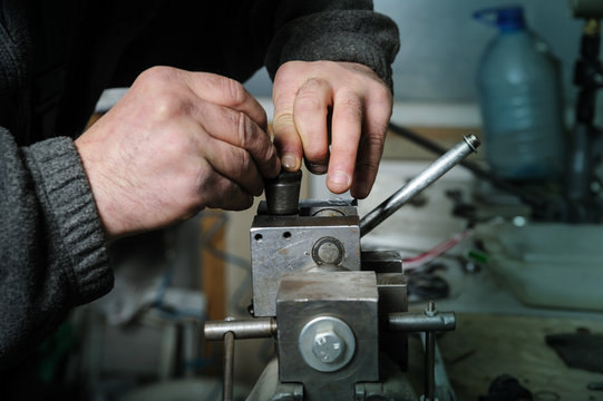 Mechanics repairing a diesel injector.