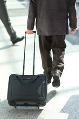 A man with a suitcase on wheels at the airport