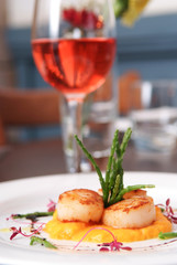 Scallops, creatively arranged food on a white restaurant plate
