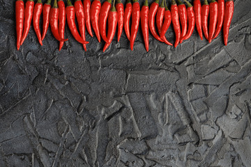 Red Hot chili pepper on a black cement background. Concrete background.