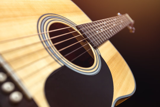 Yellow acoustic wooden guitar on a black background
