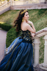Beautiful woman in a luxurious blue dress with a long train