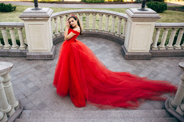 Naklejka premium Beautiful woman in a luxurious red dress with a long train