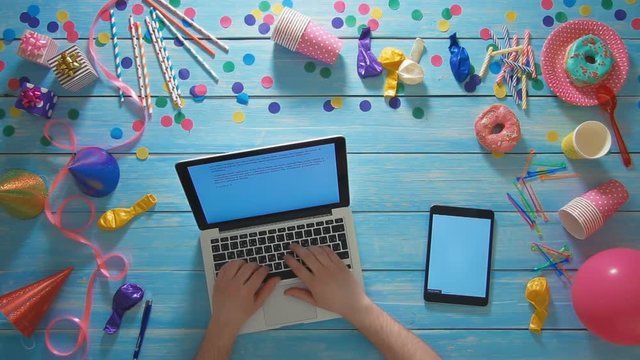 Top view man planning birthday party using laptop computer and digital tablet