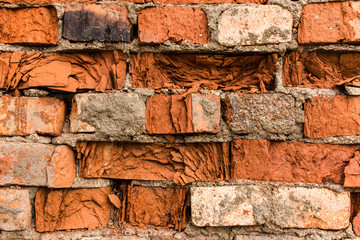 Fragment of old brick wall made of red brick.
