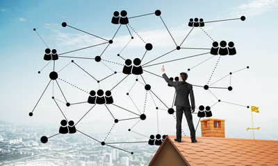 Businessman on house roof presenting networking and connection concept. Mixed media