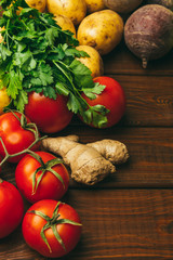 Fresh tomatoes, parsley, potatoes and beets on rustic wooden background. Farmer's healthy food concept