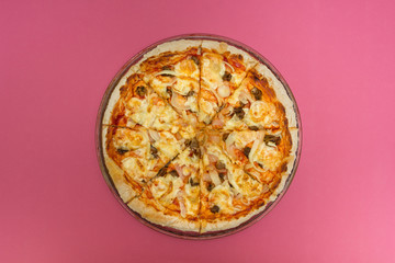 Homemade pizza on a pink background.