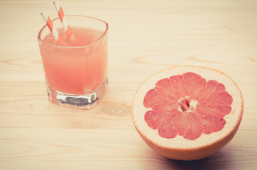 grapefruit juice with fruit on a table/juice and grapefruit on a wooden table