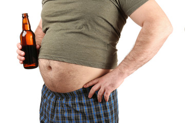 Man with big belly holding bottle of beer on white background