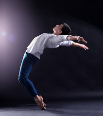 Handsome young ballet dancer on dark background