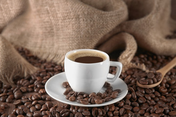 Cup of coffee with roasted beans on  table