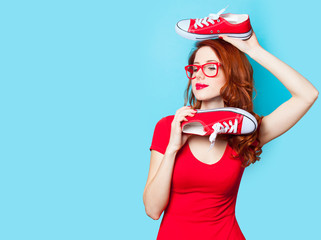 photo of beautiful young woman with red gumshoes on the wonderful blue background