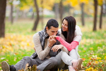 Fototapeta premium photo of handsome man kissing his woman hand on the wonderful autumn park background