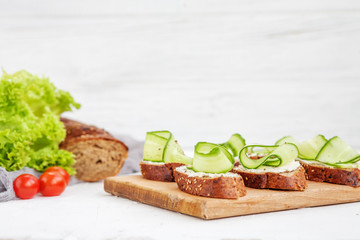 Sandwiches with cheese feta and cucumber. Lettuce and cherry tomatoes. The concept of food and vegetarianism.