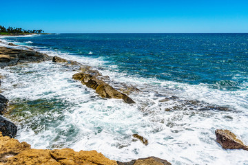 Fototapeta na wymiar Waves of the Pacific Ocean crashing on the rocks on the shoreline of Ko Olina on the island of Oahu in the island state of Hawaii 