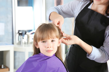 Cute little girl in hairdressing salon