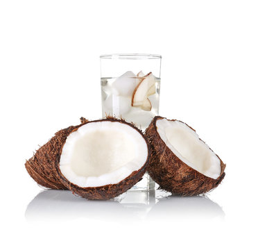 Glass of coconut water and fresh nut on white background