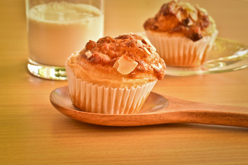 Delicious homemade almond muffins and a glass of milk on wooden table. Healthy food concept