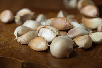 Garlic and garlic press on rustic wooden wooden background