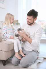 Father and his daughter with cat at home