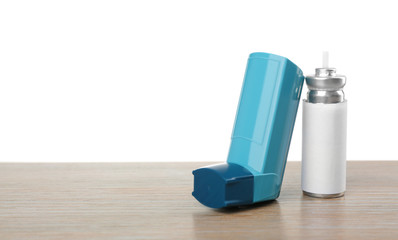 Asthma inhaler on wooden table