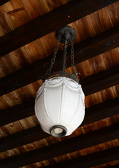 An old dirty pendant lamp hanging from wooden ceiling.