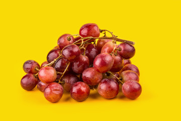 fresh and delicious red grapes isolated on yellow background