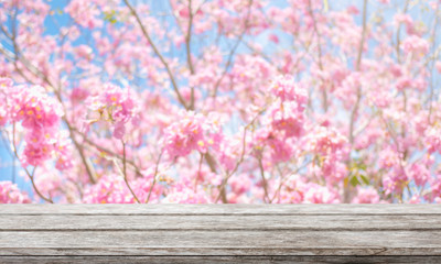 Wood table top and blurred flowers background with vintage filter