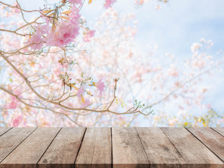 Wood table top and blurred flowers background with vintage filter
