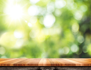 Empty brown wood table top with green blur nature sun light,Mock up for display or montage of...