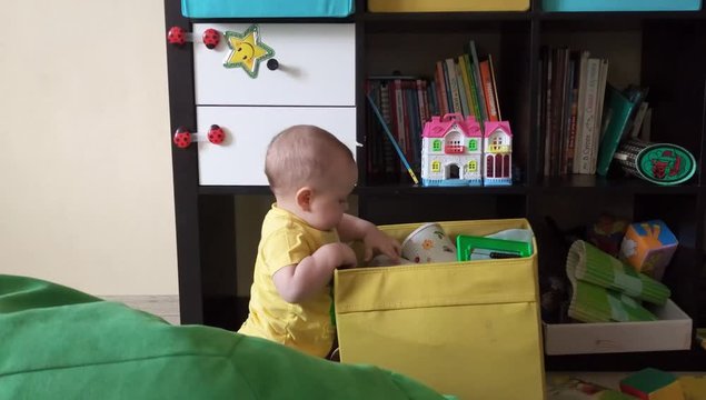A small child is playing with toys in a box in the children's room