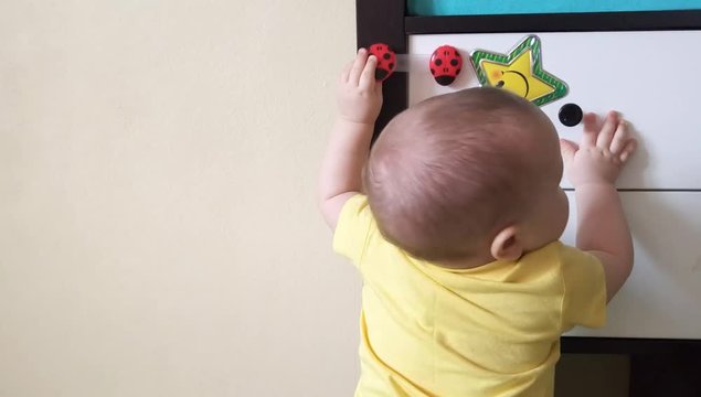 A small child plays with toys in the children's room pasted to the closet