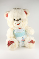 Teddy bear in a diaper on a white background