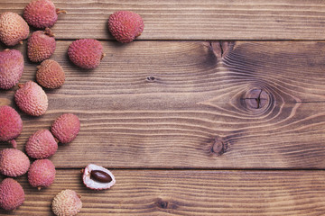 Wooden background with lychees on the edge