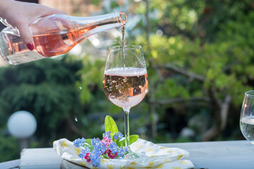 Waiter pouring a glas of cold rose wine, outdoor terrase, sunny day